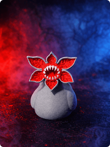 A gray vase with a red, demon-like flower decoration with sharp teeth, placed on a dark surface with a red and blue smoky background.