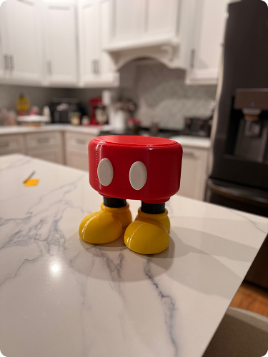 A small figure resembling Mickey Mouse's legs and lower body on a kitchen countertop.