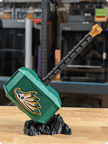 Lego replica of a Calgary Flames hockey stick and puck on a wood surface with electronic equipment in the background.