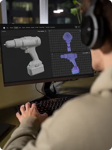 A person using a computer to view 3D models of a cordless drill and a robotic arm on the screen.
