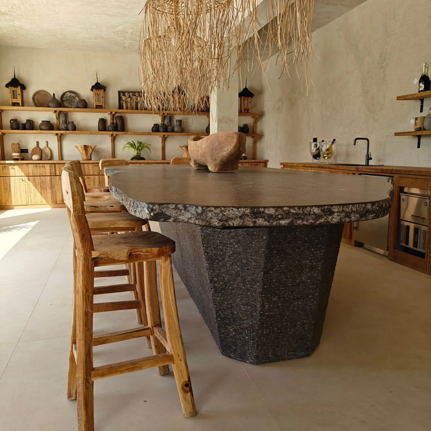 This bar deserves a moment. 👀 

Because it's one of the most unique eye-catchers we've ever designed. Made in Belgium from local Bluestone, finished with handcarved rustic textures.

Combined with the natural teak, raffia and root furniture, it's th