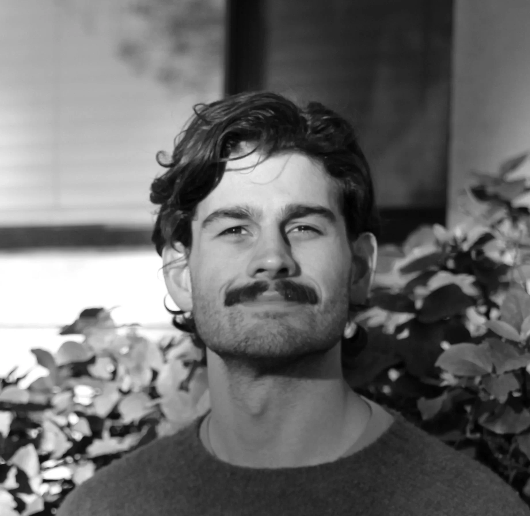 Author picture of Nick Martino from shoulder up, black and white, with plants in background
