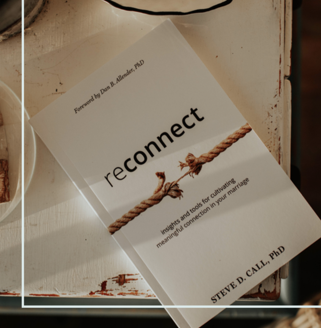 Book titled 'Reconnect' by Steve D. CAL, PhD, with a rope graphic on the cover, placed on a wooden surface.