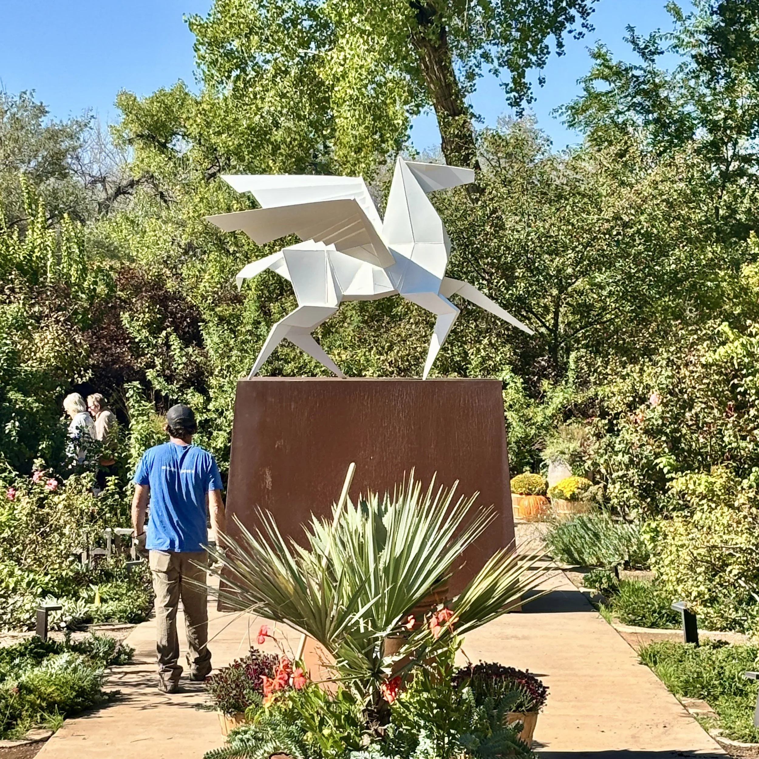 A white pegasus stands on a brown base at the ABQ BioPark Botanic Garden.