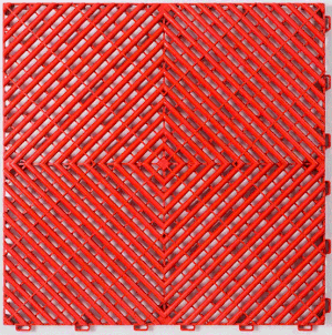 Close-up of a red rubber mat with a geometric diamond pattern and textured surface.