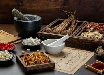 Ingredienti di cucina orientale disposti su un tavolo, tra cui un mortaio, erbe secche, salse e vari condimenti, con un menu o appunto scritto.