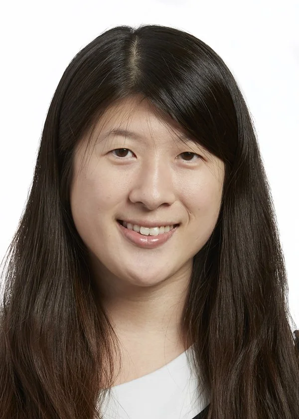 Headshot of a young woman with black hair, smiling.