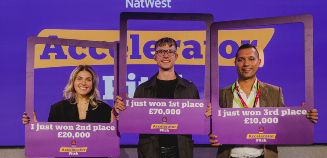 A picture of 3 people standing in front of a purple background that says Nat West Accelerator Pitch. They all are holding photo frames one says I won 2nd place,£20000,the other says I just won 1st place £70,000 and the next I just won3rd place £10000