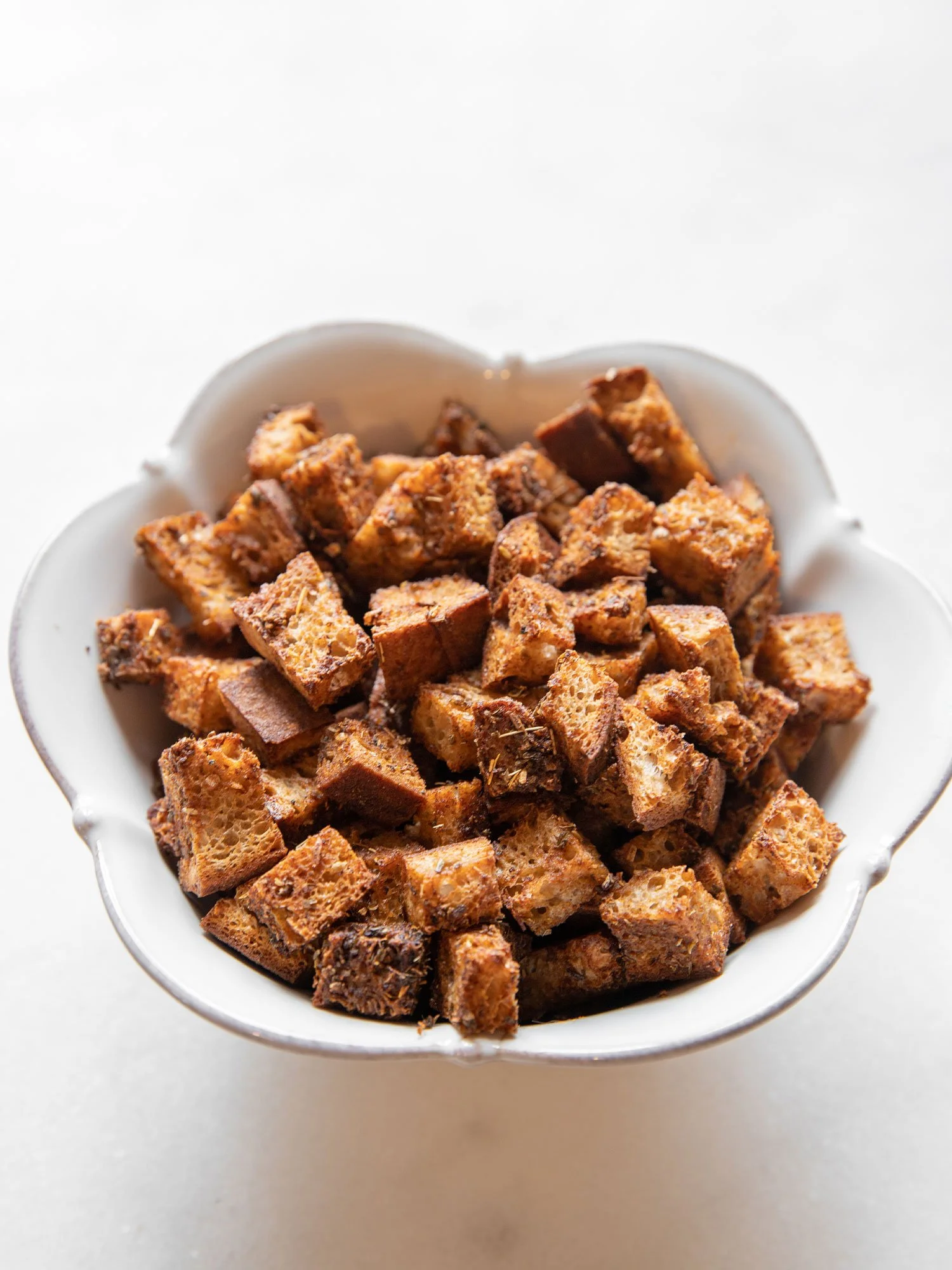 Cubos de pão integral torrado em uma tigela branca.