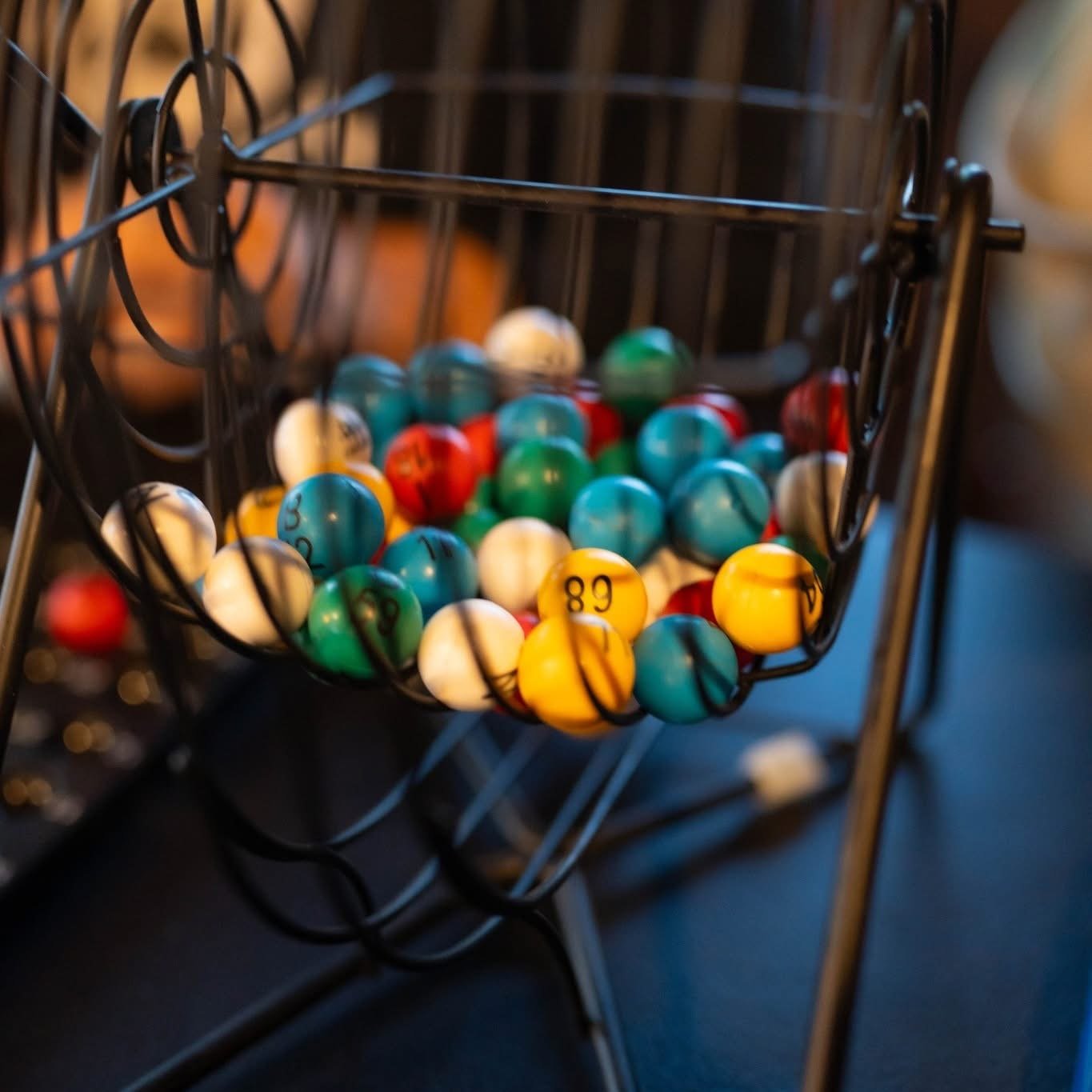 A wire basket filled with colorful numbered lottery balls.