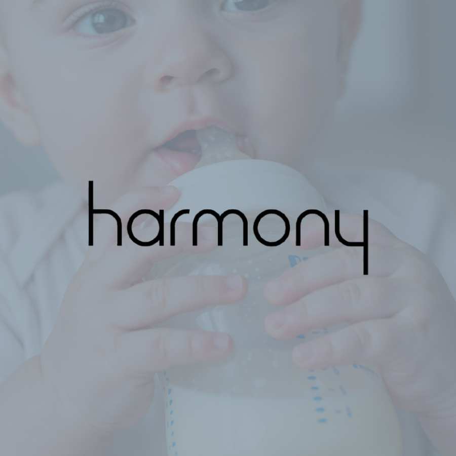 A baby drinking from a bottle with the word 'harmony' overlaid.