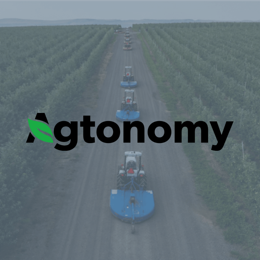 Aerial view of a line of tractors working autonomously in a green farm field.