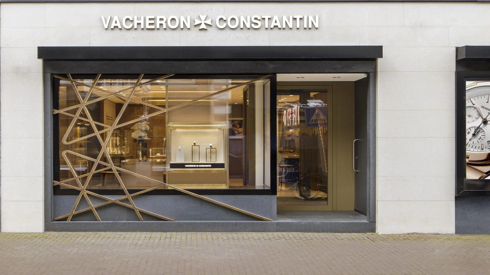 ChatGPT a dit :The façade of a Vacheron Constantin boutique featuring a large display window and golden metal exterior decorations.