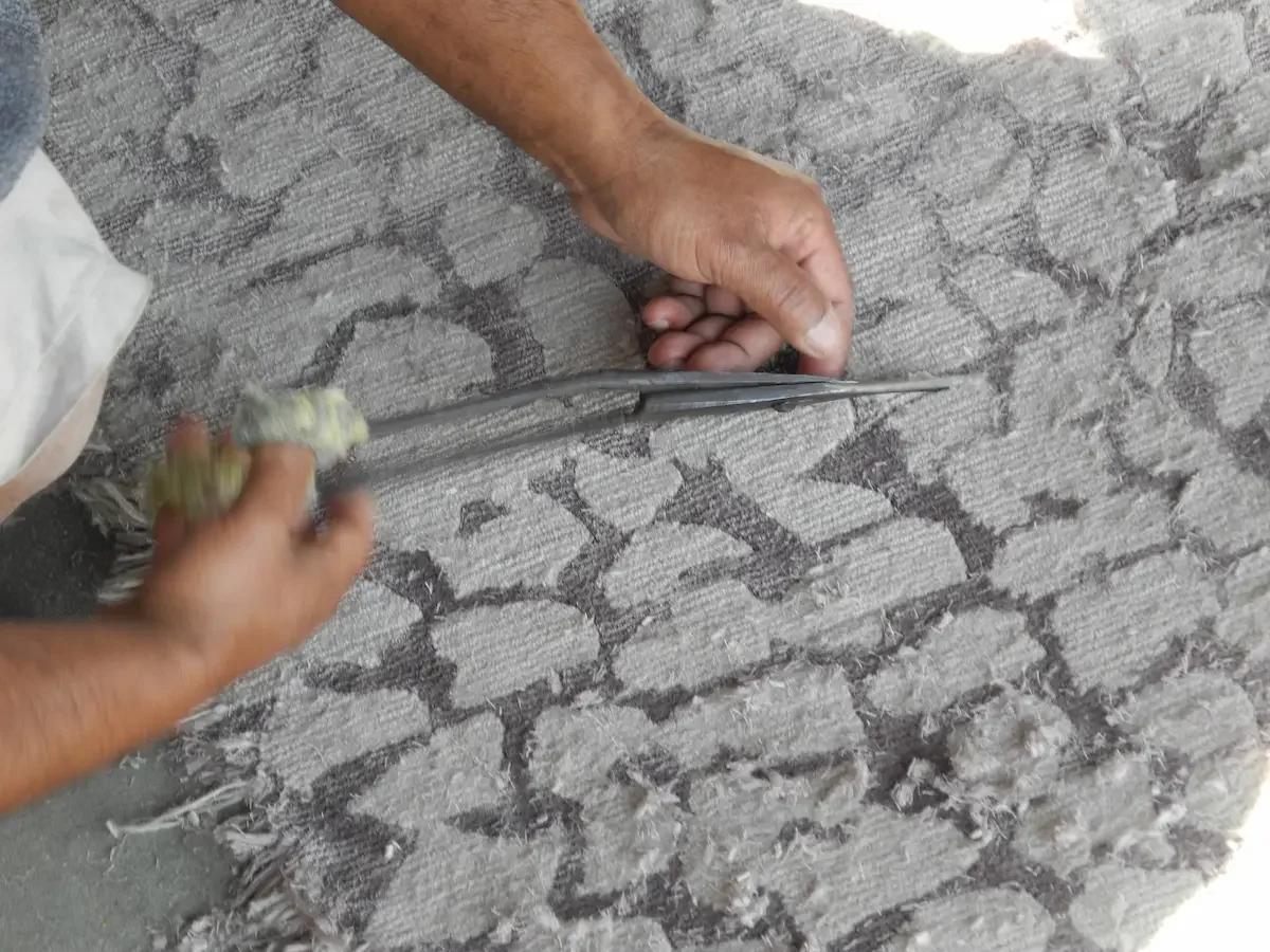 Une personne utilisant un outil pour coller des pierres sur un mur.