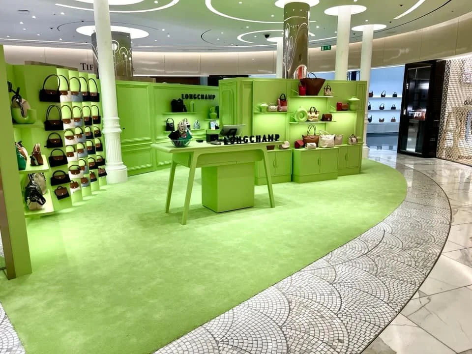Un stand de sacs à main en vert dans un centre commercial