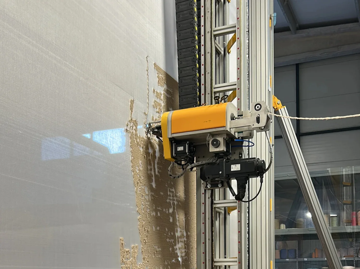 A rug showing an auto-tufted machine producing a rug on a large board in an industrial setting.