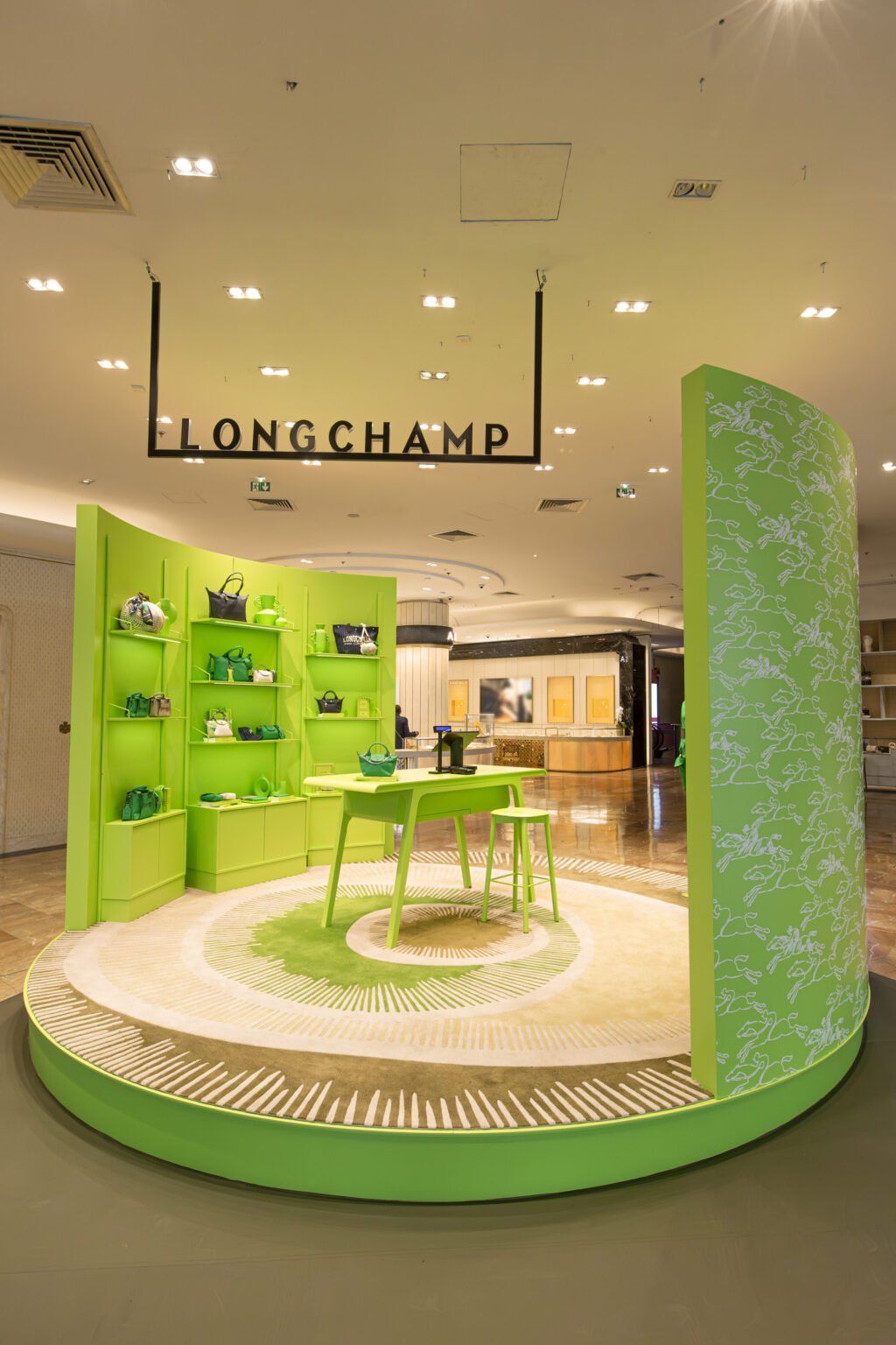 ChatGPT a dit :A display area featuring green handbags in a Longchamp boutique, with shelves in the background and bright lighting.
