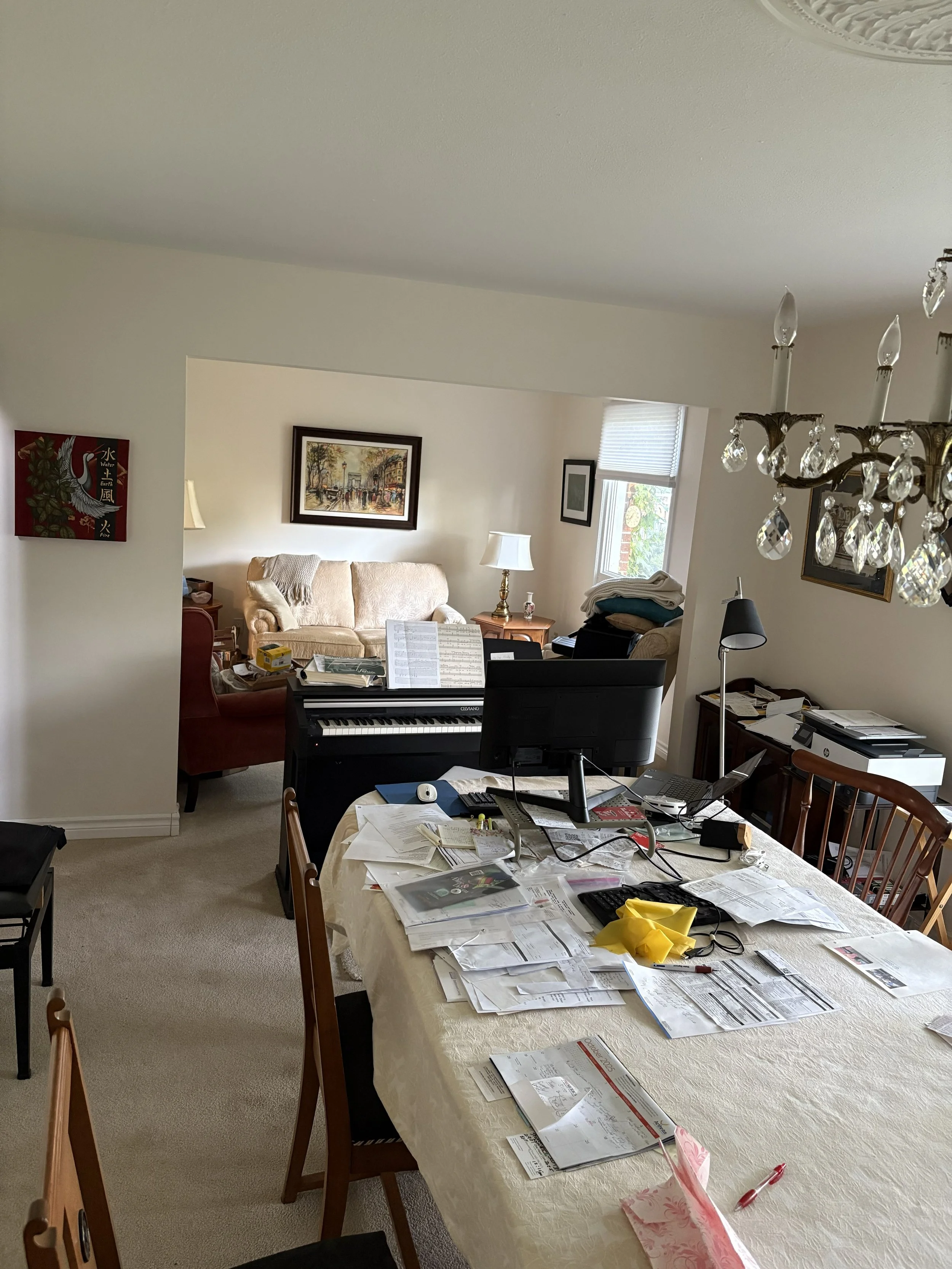cluttered living room and dining room with electric keyboard blocking passage between the two rooms