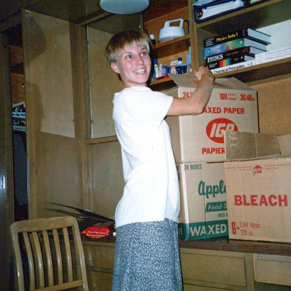Smiling young women opening boxes in dorm room that has ample storage