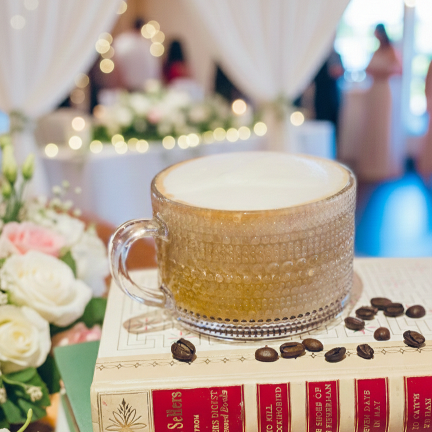 Two glasses of chai tea with crushed lavender flower sprinkles, served on a white plate with a gold rim.