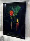 Dark digital screen displaying a single red rose with green leaves and a golden candle.