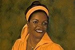 A portrait of a smiling woman with dark skin, wearing a yellow headband and yellow clothing, against a brown background.