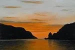 Sunset over a body of water with silhouetted hills or cliffs on either side