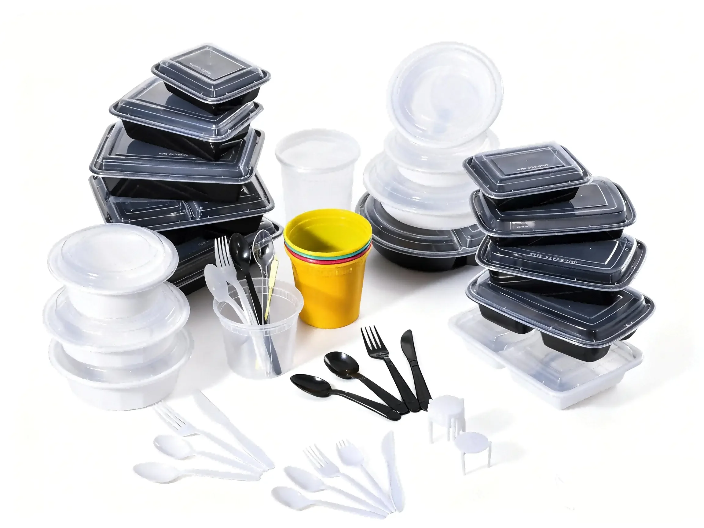 Stacked black and clear plastic food containers, disposable utensils, and colorful cups, arranged on a white surface.