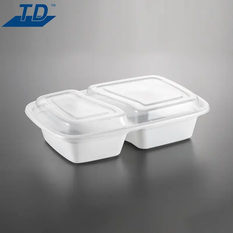 White plastic food container with two compartments and clear plastic lids, placed on a grey surface.