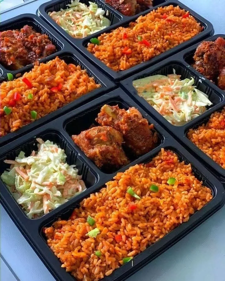 Packaged meal with fried chicken, coleslaw, and seasoned rice in black compartmental trays.