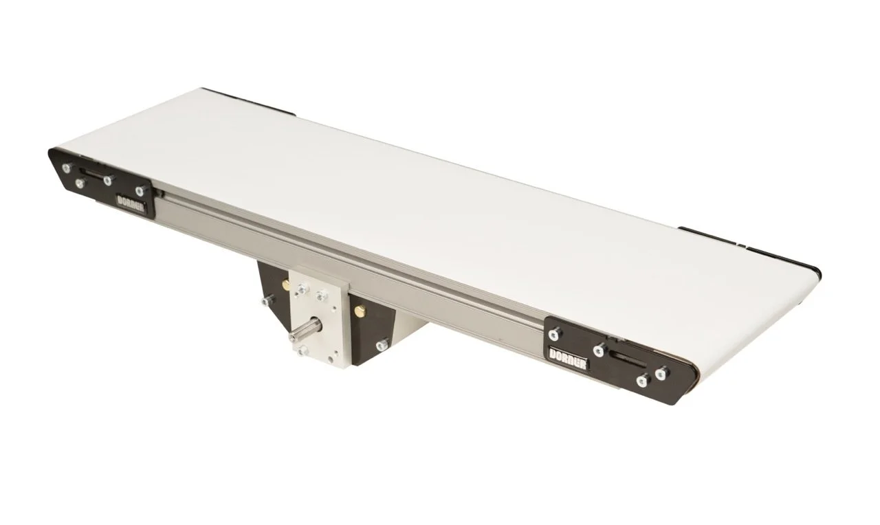 A long, flat, rectangular machine with a white surface and black side panels, mounted on a central mechanical support.