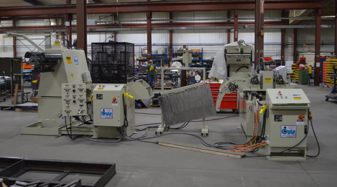 Industrial machinery setup in a manufacturing workshop, with various equipment and tools in the background.