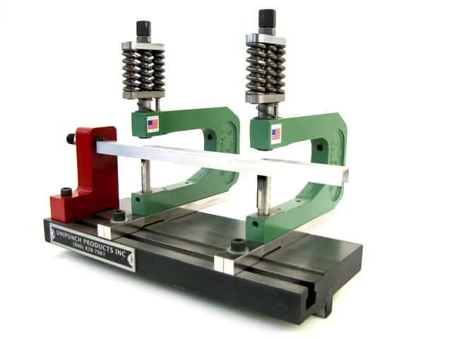 A specialized machine with green and red parts, metal springs, and a black base, used for precision manufacturing or assembly.