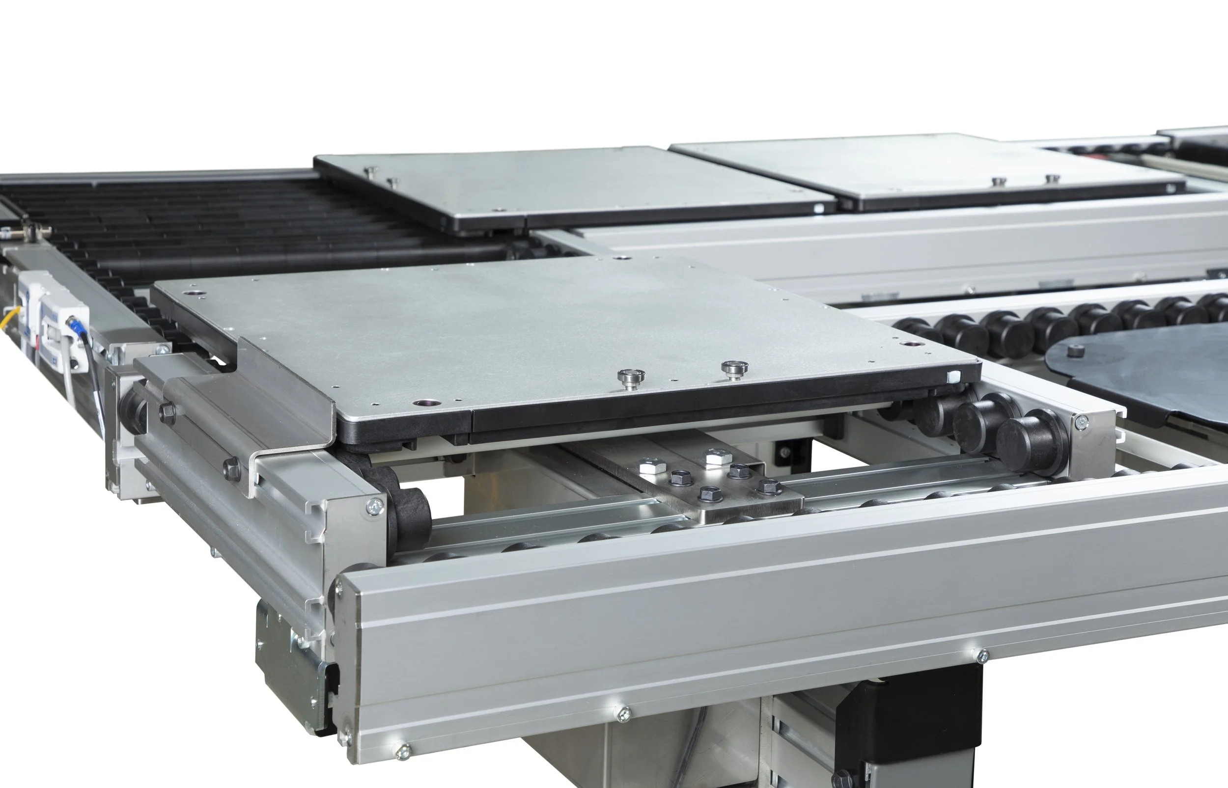 Industrial conveyor system with metal platforms and rollers.