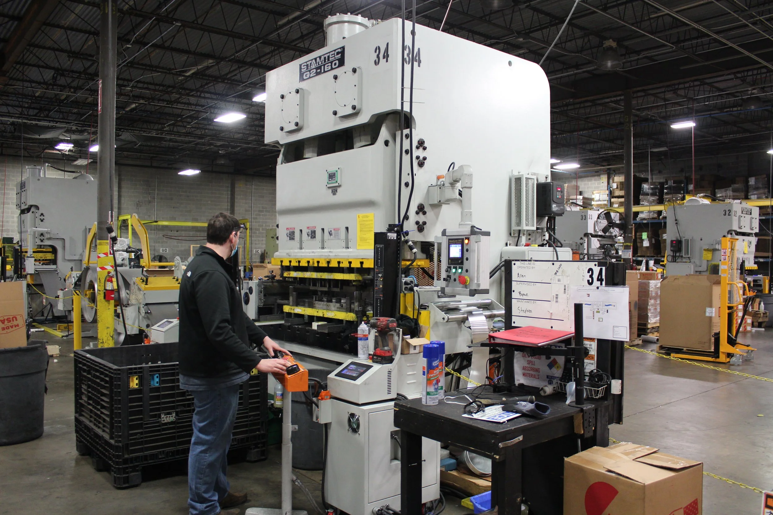 A man operating a large industrial machine in a warehouse or factory setting.