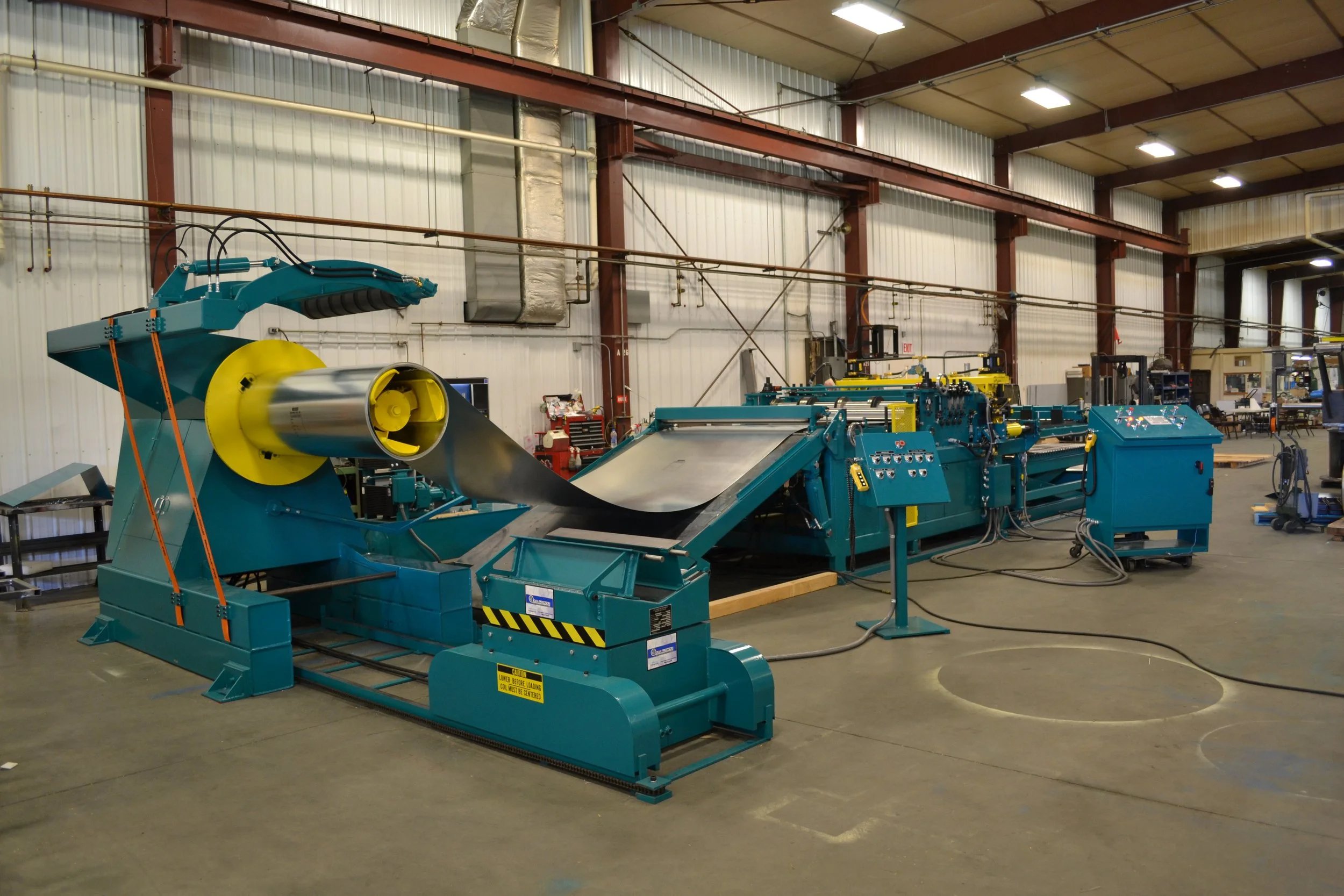 Industrial manufacturing equipment inside a factory workshop with various tools and machines.