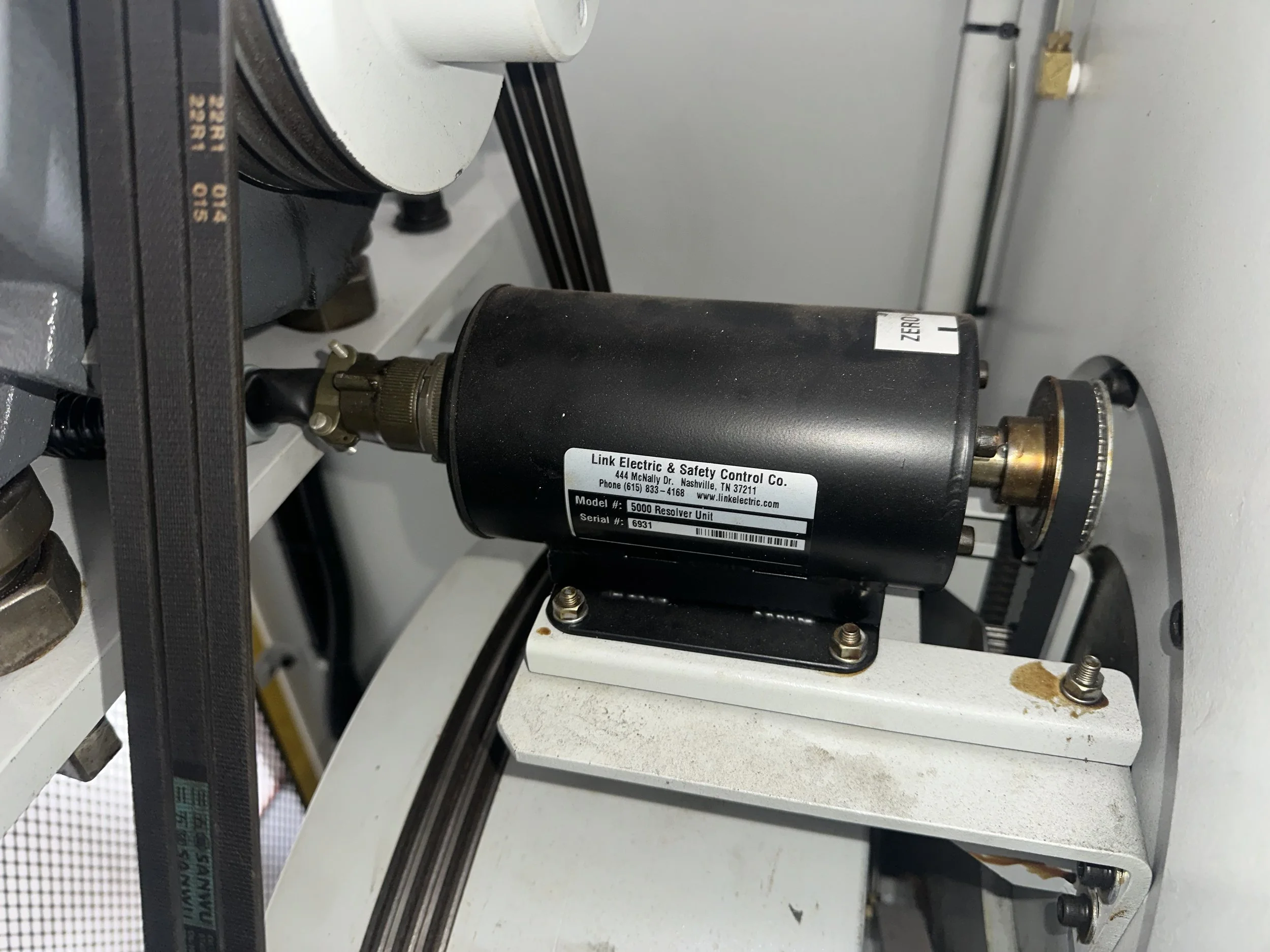 Close-up of a black electric safety control unit labeled 'Link Electric & Safety Control Co., Model 5000 Resolver Unit, Serial 6931, located on a white metallic surface of industrial machinery.