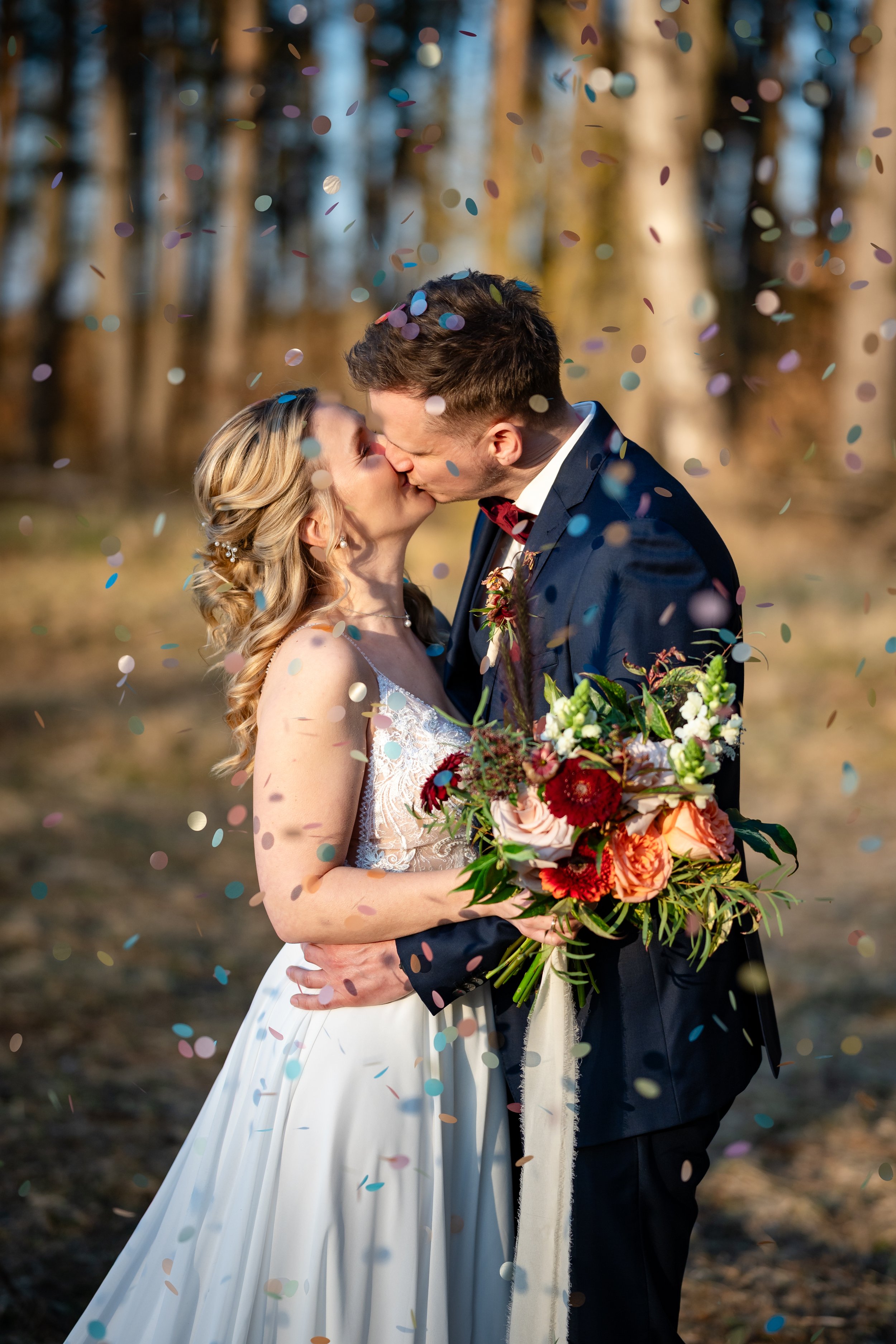 Ein Hochzeitspaar küsst sich im Sonnenuntergang vor einem Wald nahe Berlin. Aufgenommen von Hochzeitsfotograf Dominic Glock.