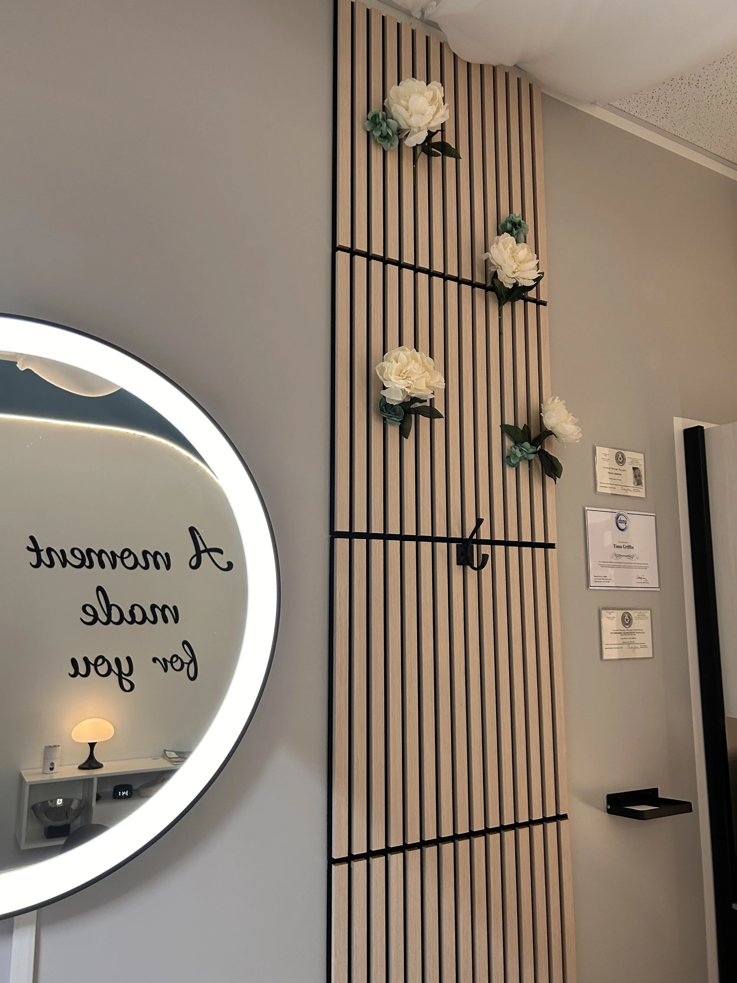 picture of mirror, bamboo slat walls, wiht flowers and chiffon hanging on ceiling