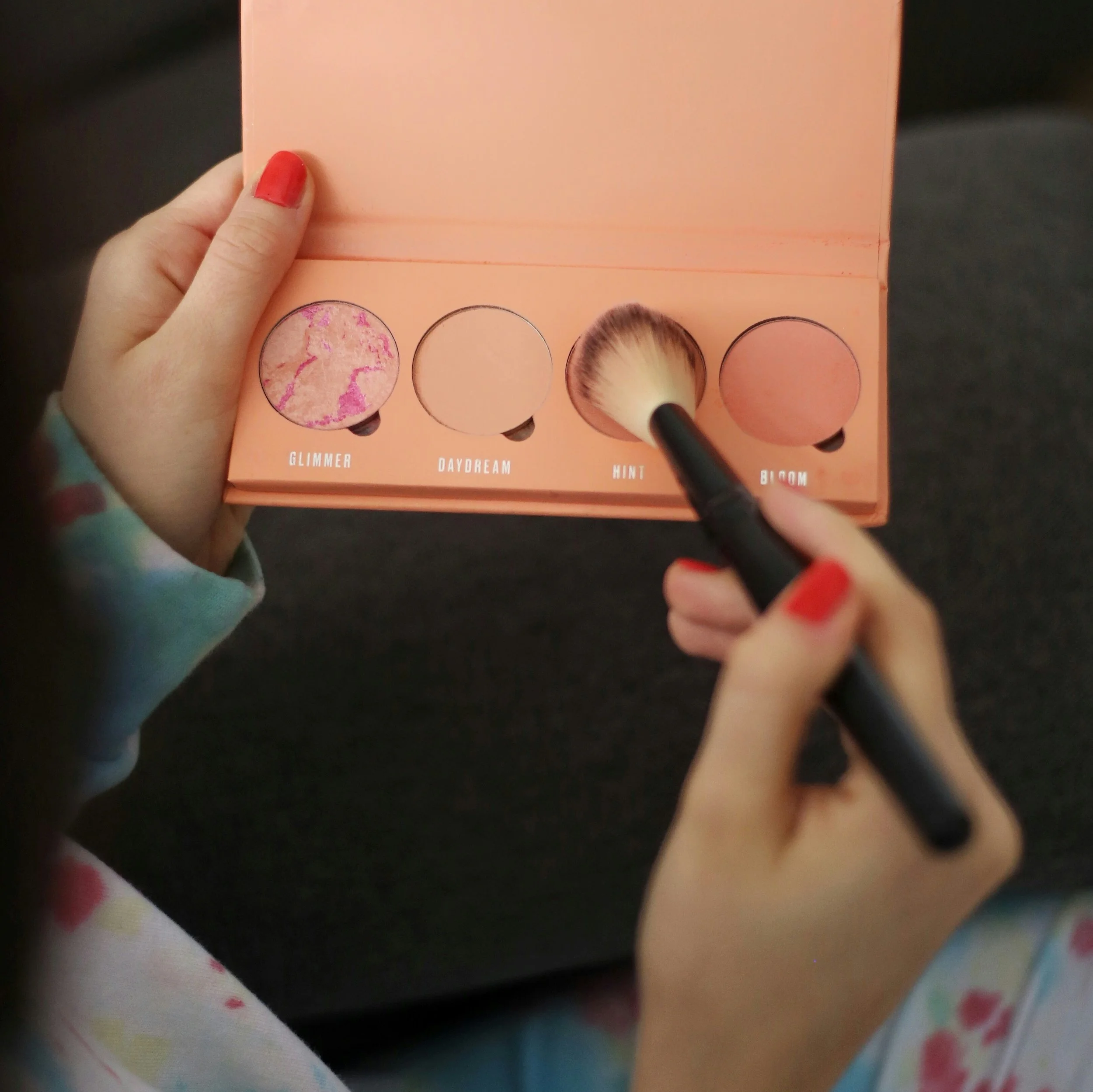 Hands holding a blush palette symbolising colour choice, expression, and individuality in permanent makeup.