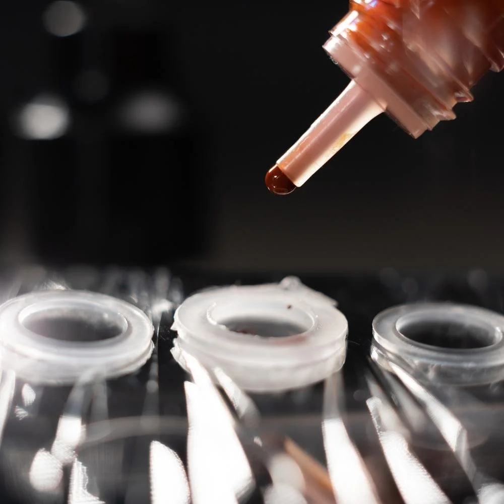 Permanent makeup artist in sterile gloves preparing pigment, symbolising safe and precise treatment.