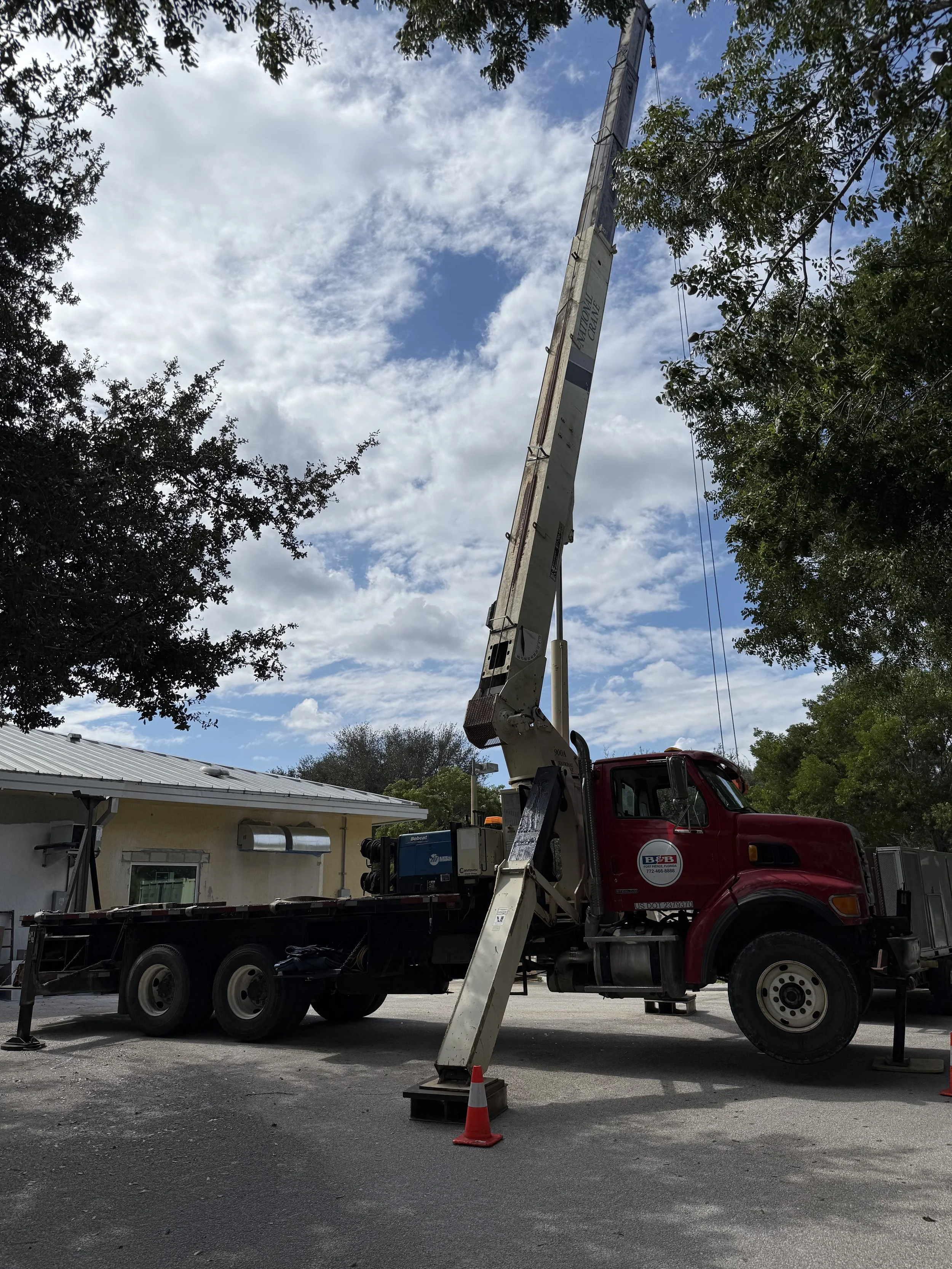 Construction site with a tall yellow crane and scaffolding on a building under construction against a clear blue sky.