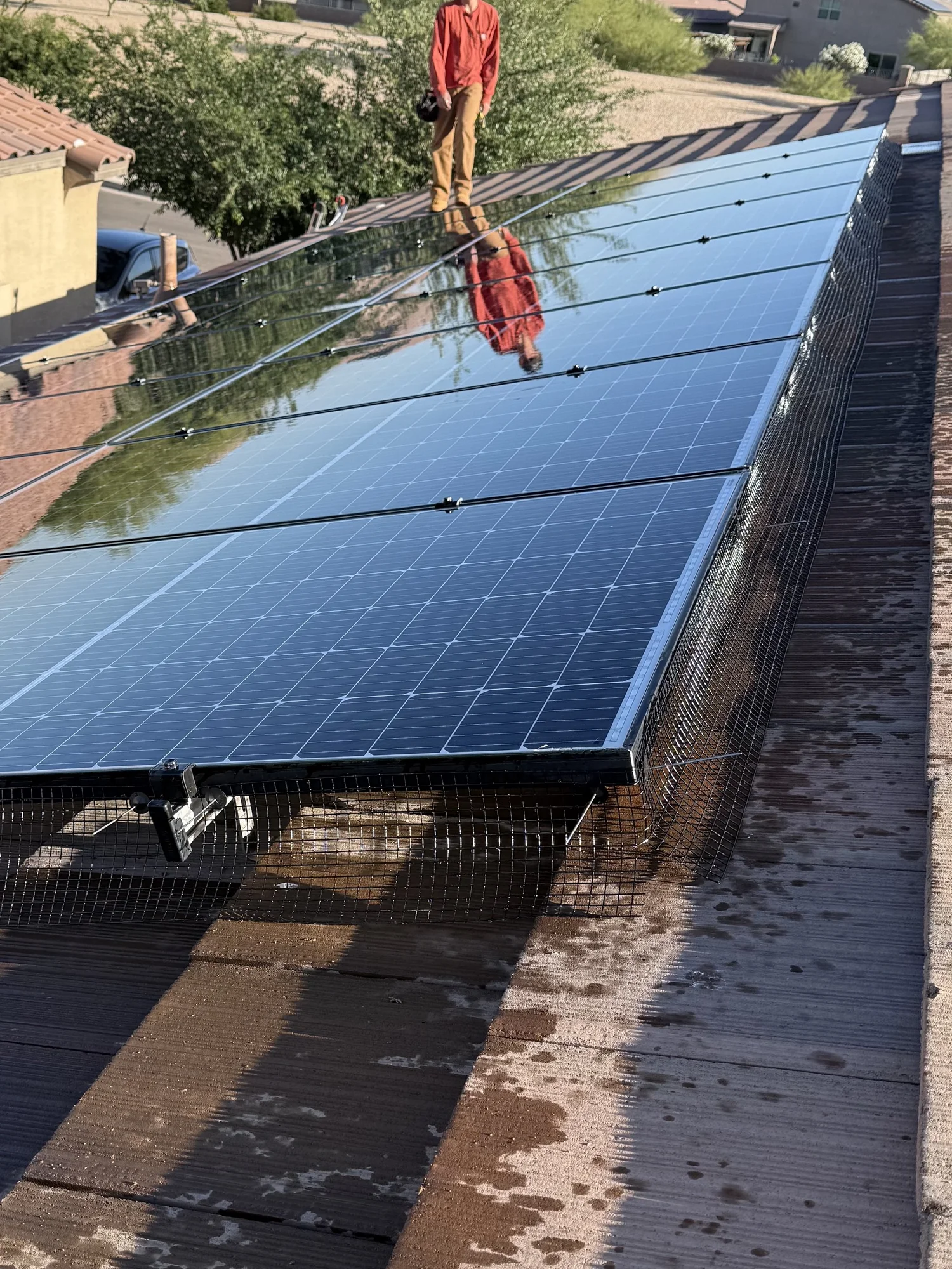 Bird guard mesh installed around solar panels on a Talon project