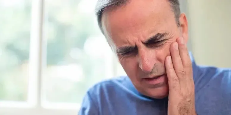 Image of a man holding his cheek