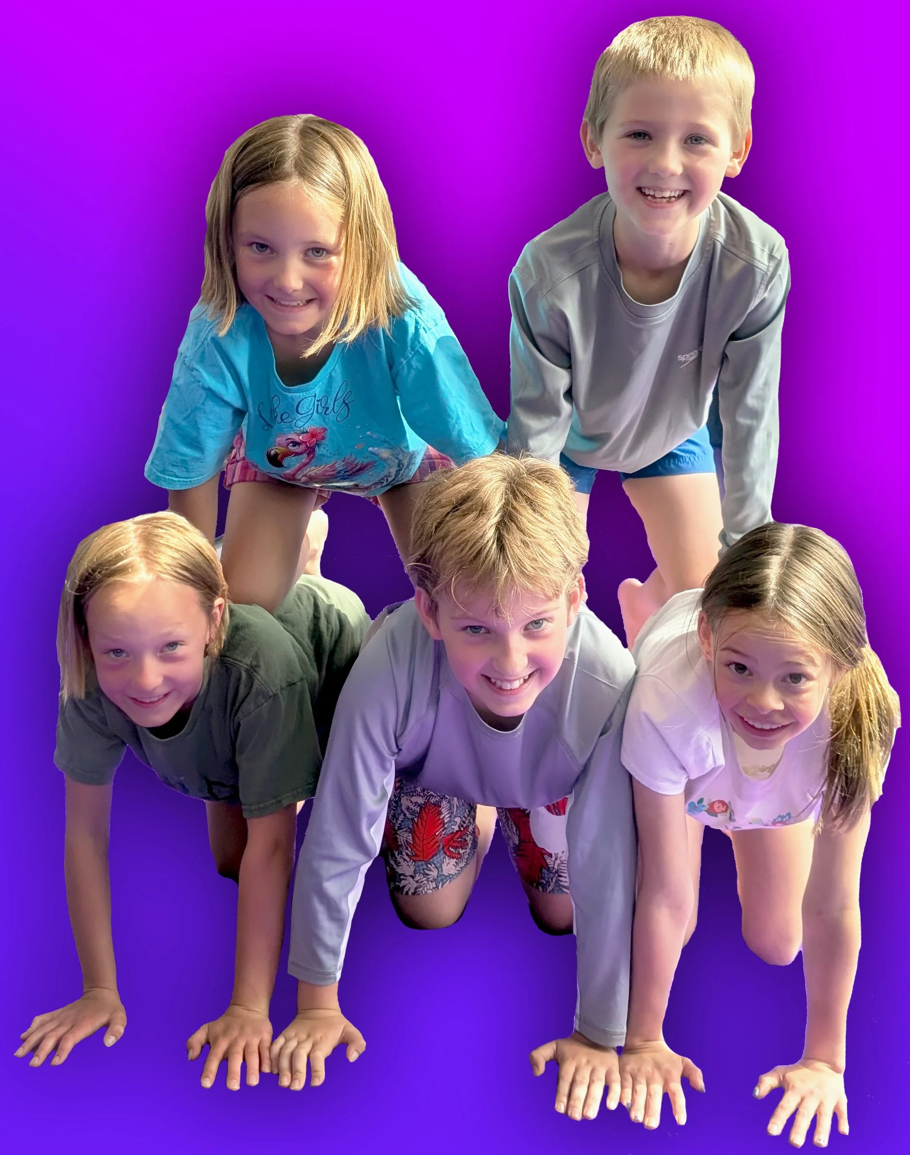Group of children in a pyramid formation, with some children crouching and supporting others standing on their backs and shoulders, against a purple background.