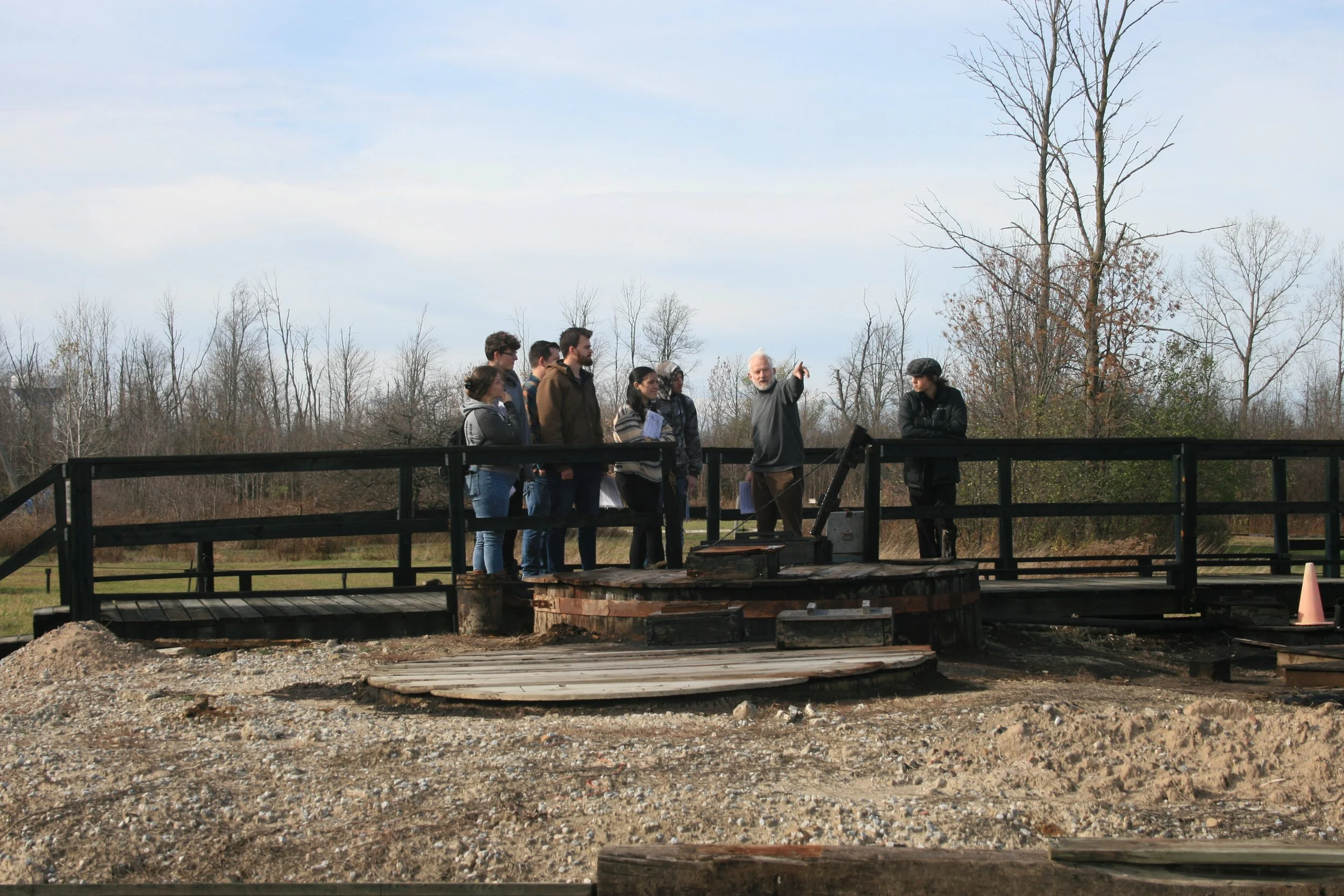OU Students learning where oil in storage tank (has metal band around it) comes from.JPG