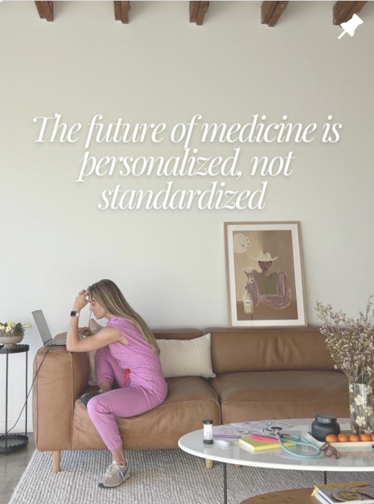 A girl in pink scrubs sitting on a brown couch using a laptop, with a quote on the wall saying, "The future of medicine is personalized, not standardized." A framed art piece, a table with medical items, and plants are also visible.