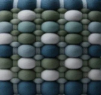 Close-up of a textured fabric with a pattern of oval shapes in shades of blue, green, and white.