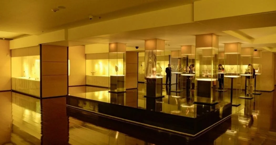 Mostrador de exhibición de joyería con vitrinas de vidrio y luces cálidas en un ambiente elegante.