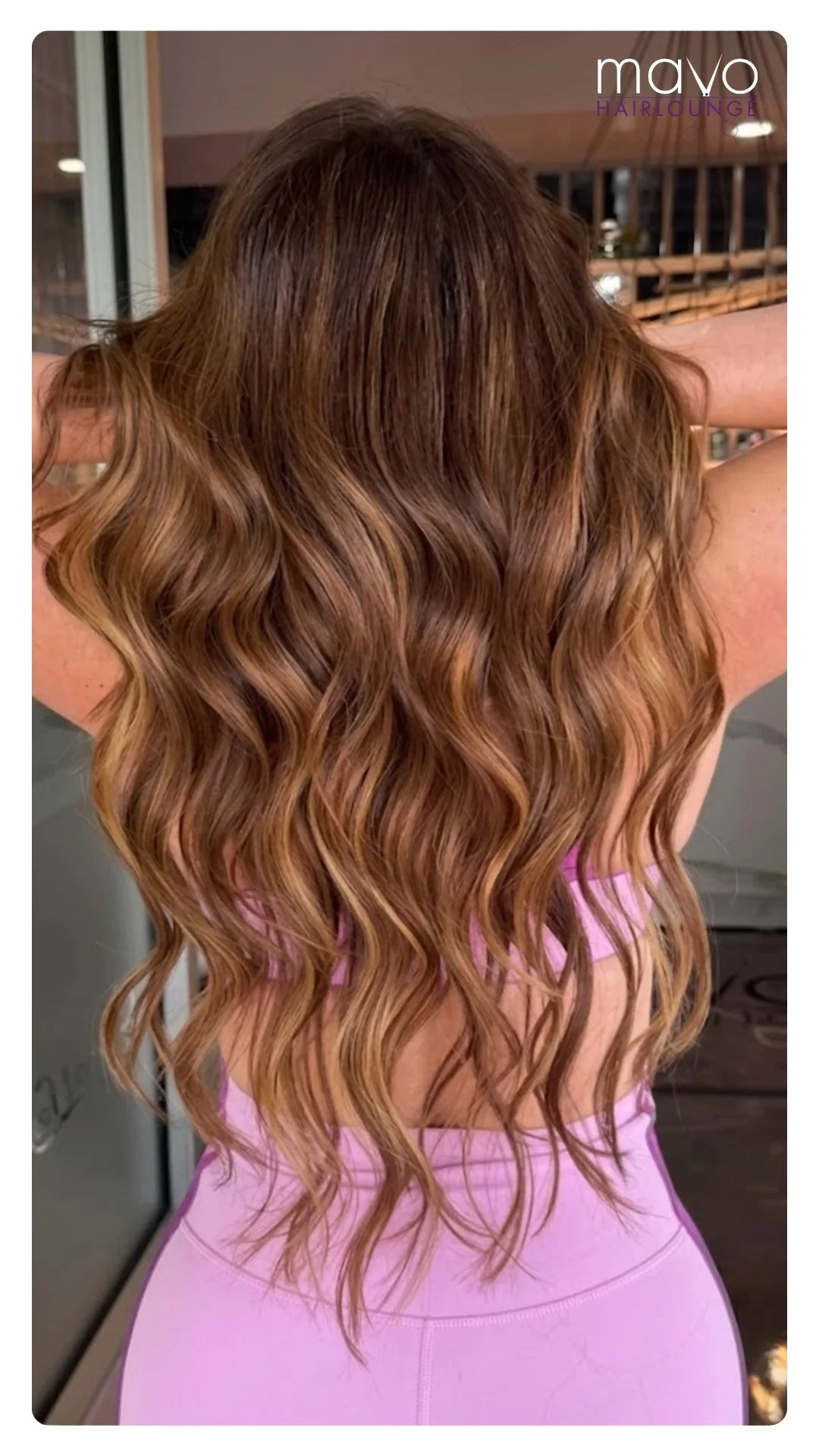 Rich, warm dimensional brunette balayage styled with a sleek wave to reflect light and shine